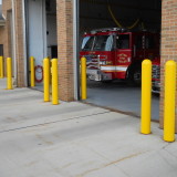 Yellow Bollard Sleeves over Steel Pipe Bollards to prevent garage door collisions