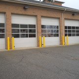 Garage entry shielded from vehicle collisions by Steel Pipe Bollards and Yellow Bollard Sleeves