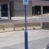 Blue bollard sign system with blue bollard cover and blue plastic post used for a handicap accessible parking spot
