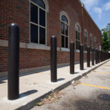 Building with brown bollard covers along walkway