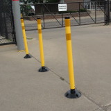 Yellow delineator posts lining facility entrance/exit gates