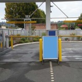 Plastic overhead clearance bars and yellow bollard covers used for car wash entrance