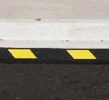 Parking block with yellow reflective stripes