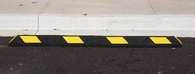 Parking block with yellow reflective stripes
